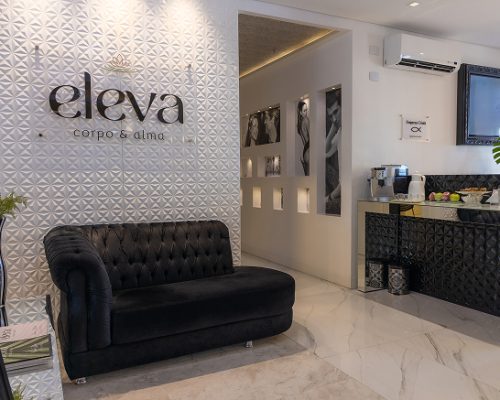 modern-spa-waiting-area-with-white-chairs-white-counter-marble-floors-natural-light